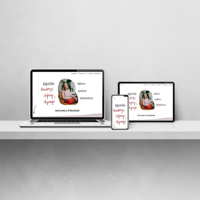 Electronic devices including laptop, tablet, and phone neatly arranged on a table, each showing the homepage of the coaching website.