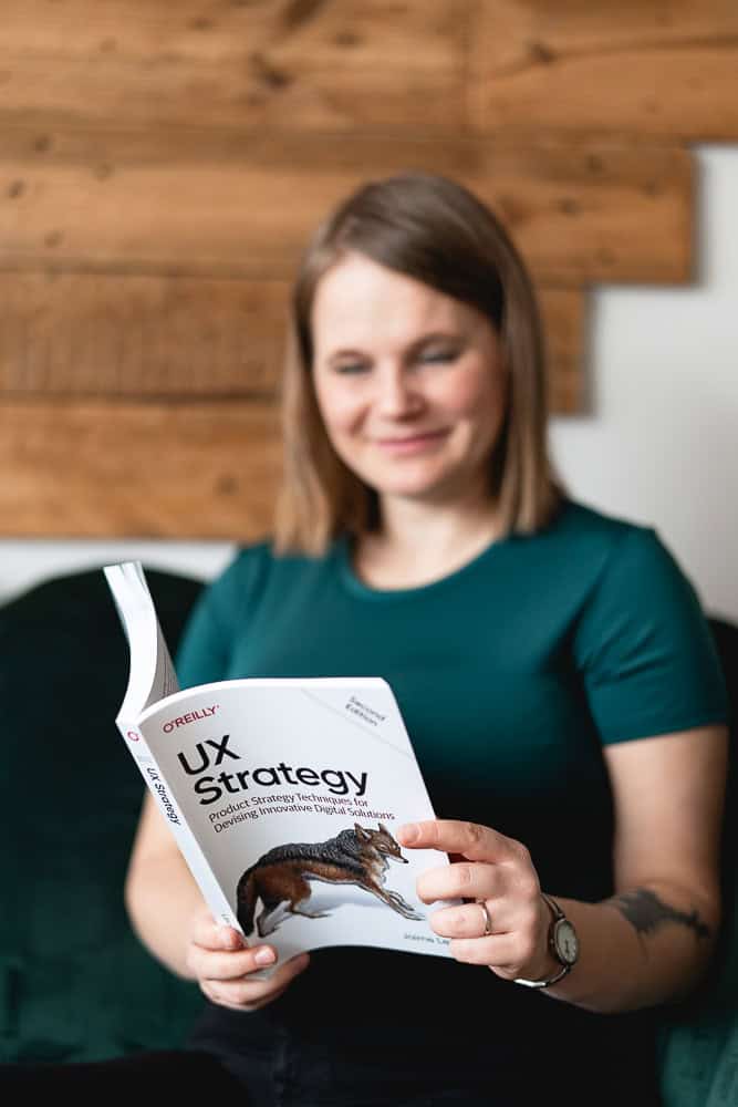 Barbora reading a book called UX Strategy, preparing a website blueprint.