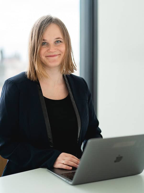 Barbora working on her laptop and smiling.